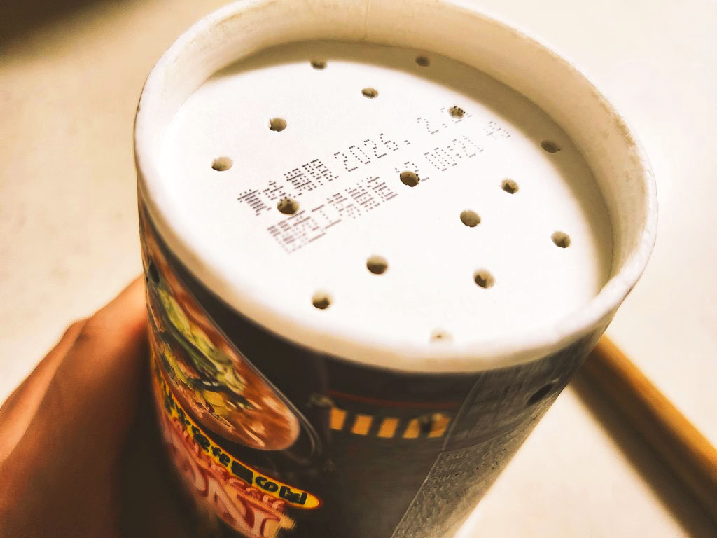 カップ麺の容器の後ろに穴をあけている画像